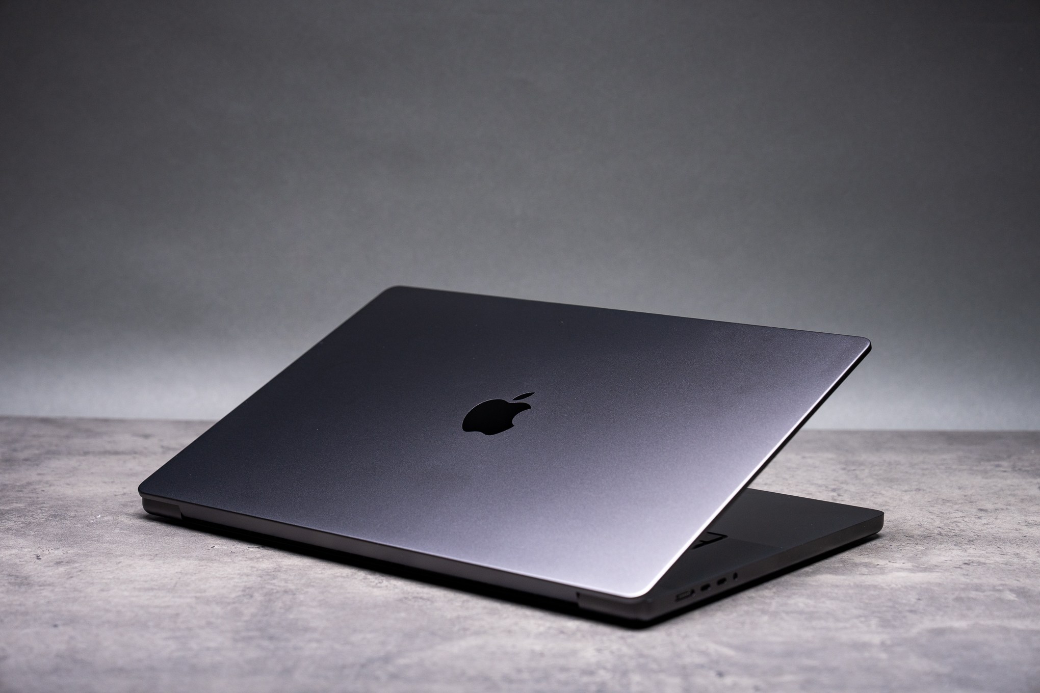 Apple logo displayed on a MacBook screen in a dimly lit setting