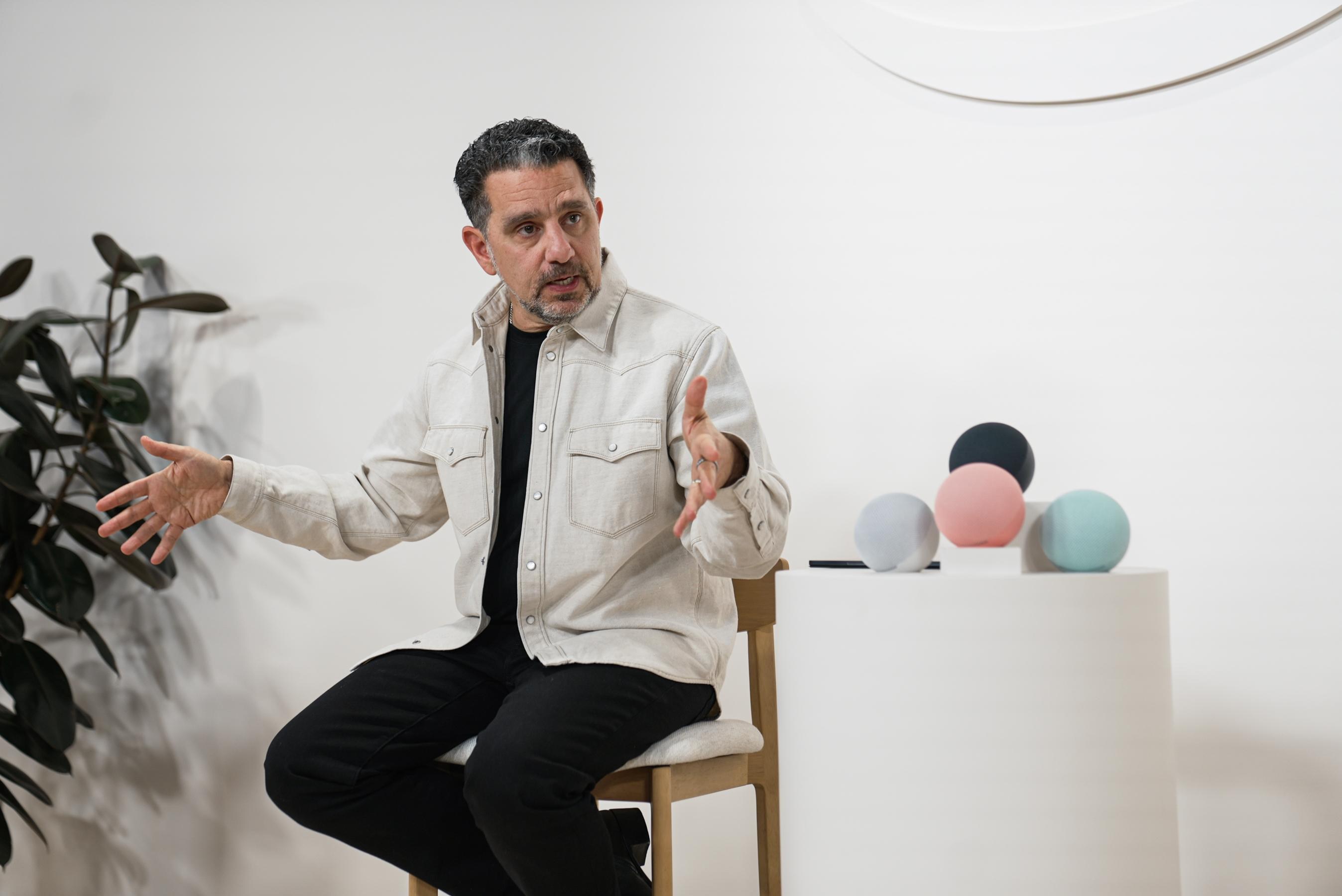 Panos Panay, Amazon's head of devices and Alexa, sitting next to the newest generation Echo Dot smart speaker.